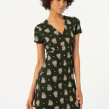 Feminine short sleeve mini dress with botanical print and elegant V-neck cut for trendy summer wardrobe essentials.