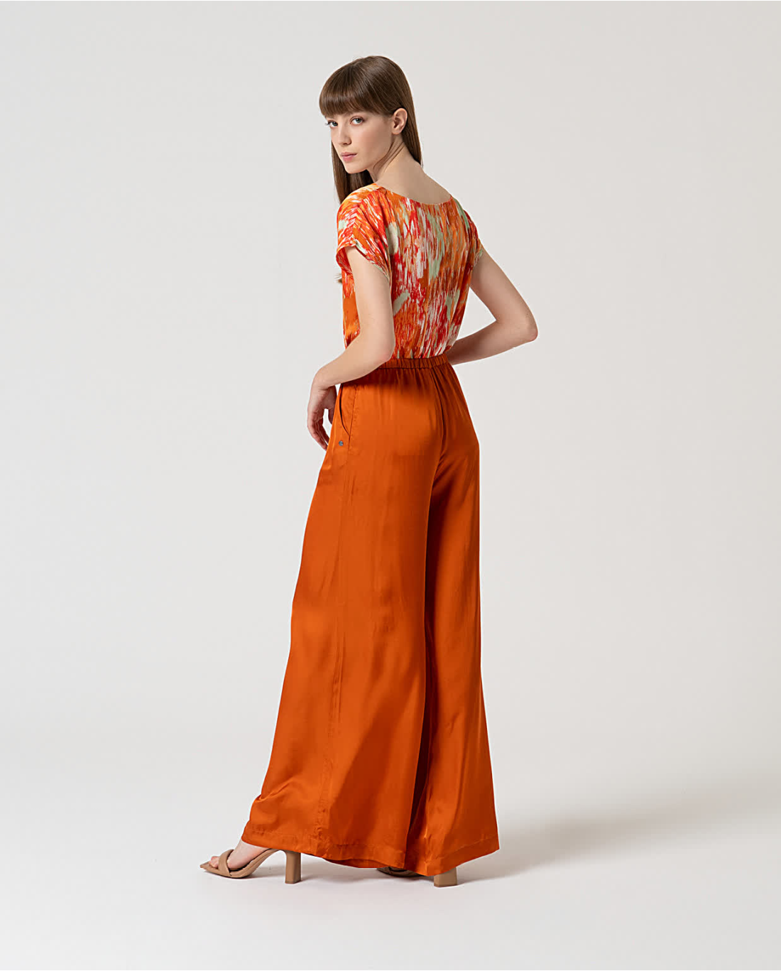 High-waisted orange wide-leg pants with a relaxed drape for women's workwear and dressy casual style.