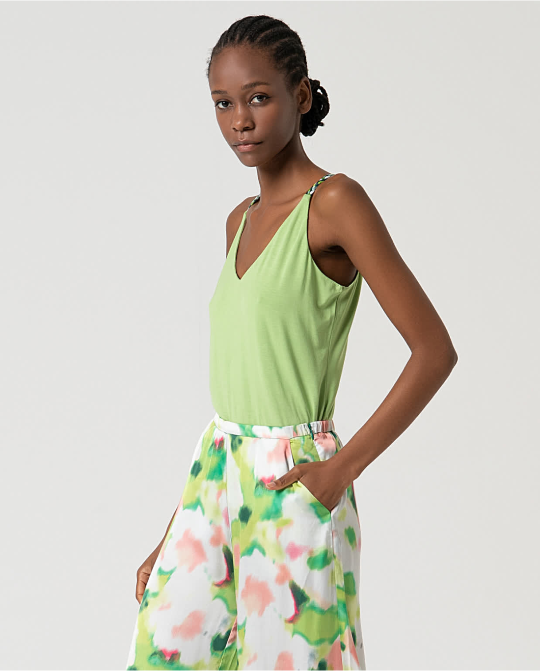 Fashionable women’s resort fashion set with flowy printed trousers and fresh lime green camisole top