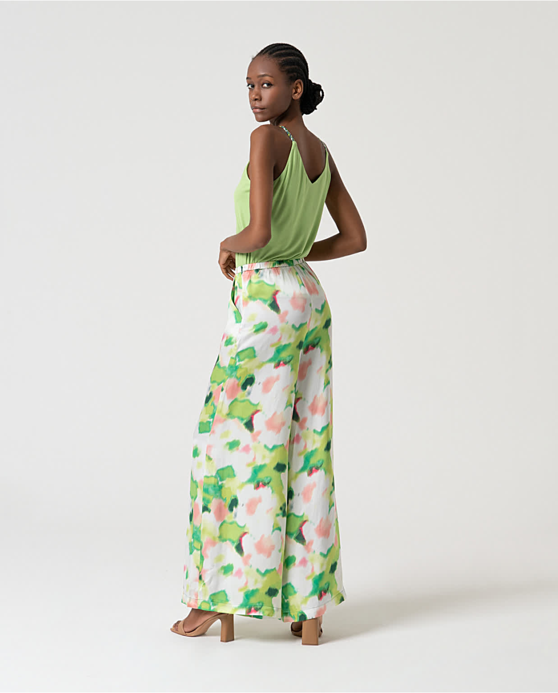 Stylish abstract print wide leg trousers paired with trendy green camisole for elevated casual resort fashion.