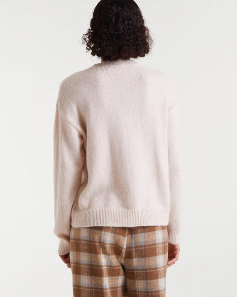 Women's cream graphic sweater with red Après Ski slogan, a cozy winter knit for ski trips, mountain holidays and après ski style.