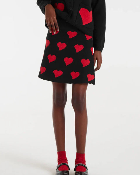 Women’s black mini skirt with red heart print and A-line silhouette for trendy date night, party, and Valentine’s Day outfits.