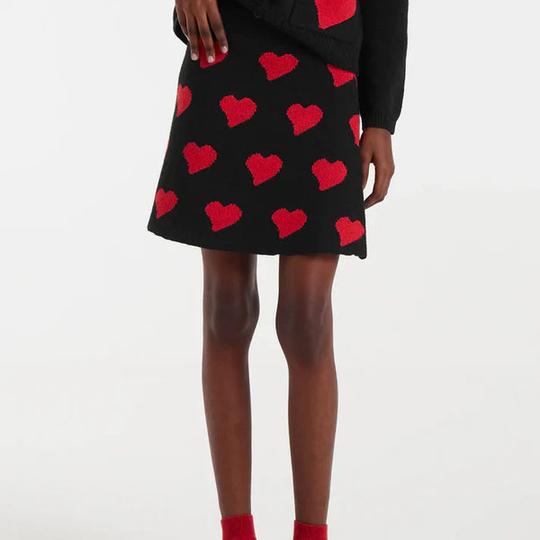 Women’s black mini skirt with red heart print and A-line silhouette for trendy date night, party, and Valentine’s Day outfits.