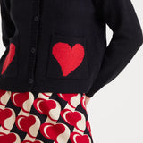 Close up of pockets on this minimalist women’s knit cardigan with standout red heart accents