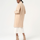 Sophisticated longline beige coat with oversized fit and contemporary quiet luxury fashion aesthetic.