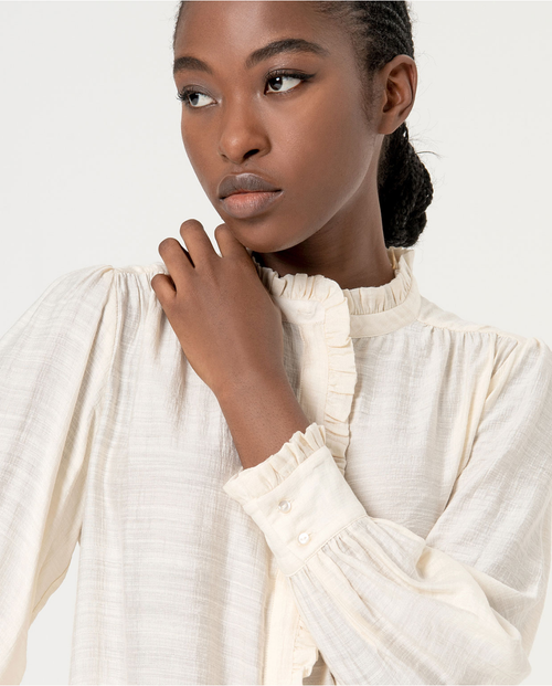 Modern ivory textured blouse featuring high collar neckline and soft tailored silhouette for elegant fashion looks.