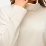 Women's relaxed fit ivory birch turtleneck sweater styled with tailored trousers for polished office and everyday outfits.