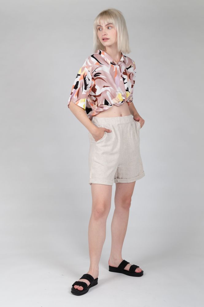 Women's beige bermuda shorts with rolled cuffs and breathable linen fabric.