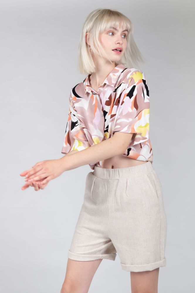 Relaxed fit oatmeal linen bermuda with rolled cuff-shorts perfect for minimalist capsule wardrobes.