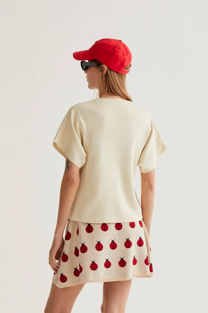 Women's cream wrap-style blouse with oversized buttons, V-neckline and short kimono sleeves for elegant everyday and resort style.