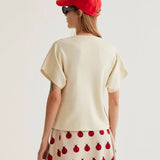Women's cream wrap-style blouse with oversized buttons, V-neckline and short kimono sleeves for elegant everyday and resort style.