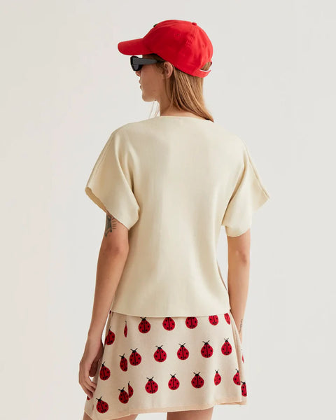 Women's cream wrap-style blouse with oversized buttons, V-neckline and short kimono sleeves for elegant everyday and resort style.