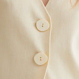 Women's neutral wrap-inspired blouse featuring an asymmetrical button-front design, soft drape and timeless boutique style.