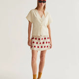 Boutique women's cream short sleeve blouse with V-neck wrap styling, oversized buttons and modern minimalist elegance.