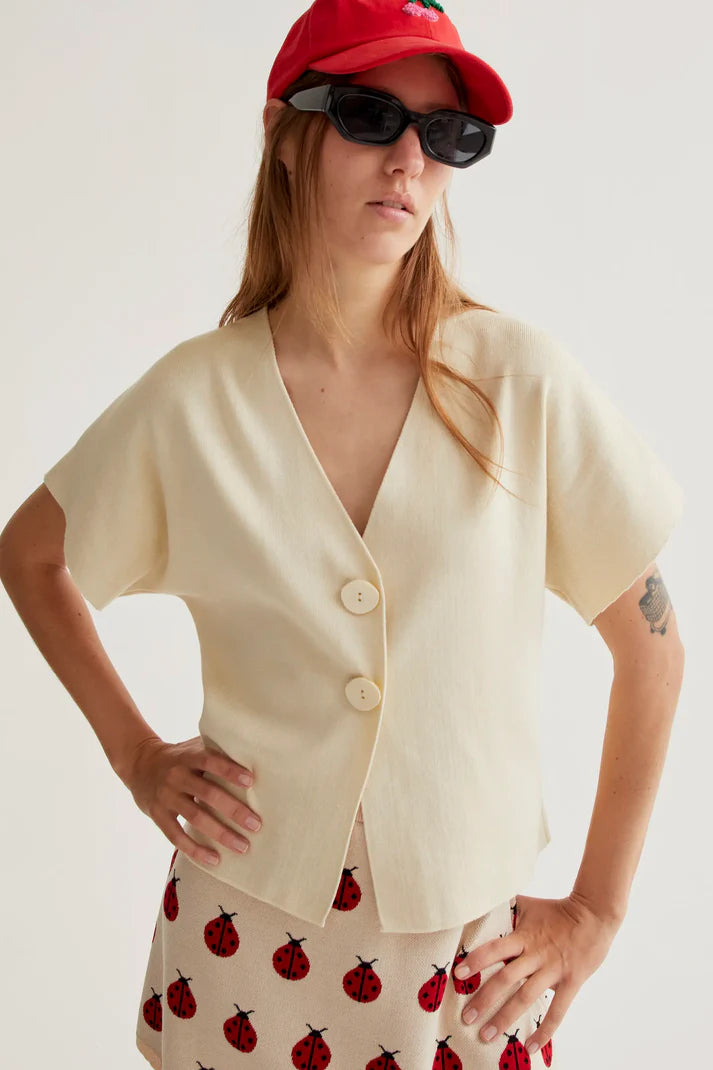 Premium boutique ivory blouse featuring an asymmetrical wrap-front design, minimalist tailoring and breathable fabric for spring and summer fashion.