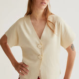 Premium boutique ivory blouse featuring an asymmetrical wrap-front design, minimalist tailoring and breathable fabric for spring and summer fashion.