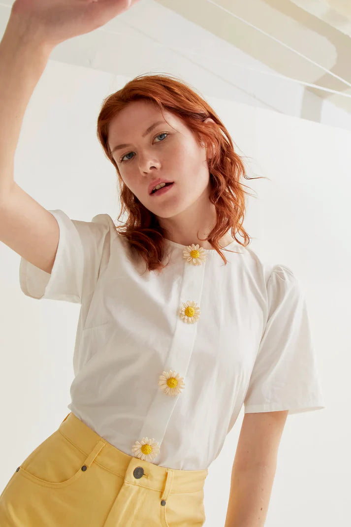 Women's elegant white floral button blouse featuring charming daisy embellishments and short sleeves for feminine spring and summer boutique style.