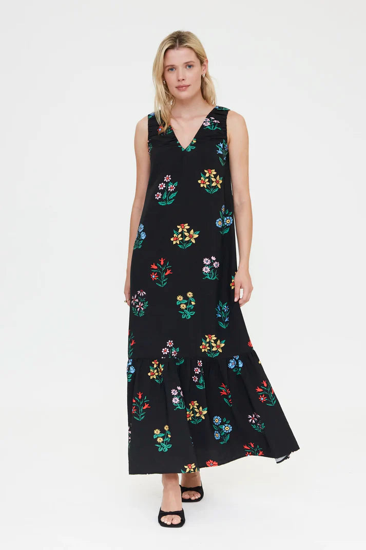 Women's black floral print maxi dress with sleeveless design, colorful botanical pattern and tiered hem for summer vacations and resort style.