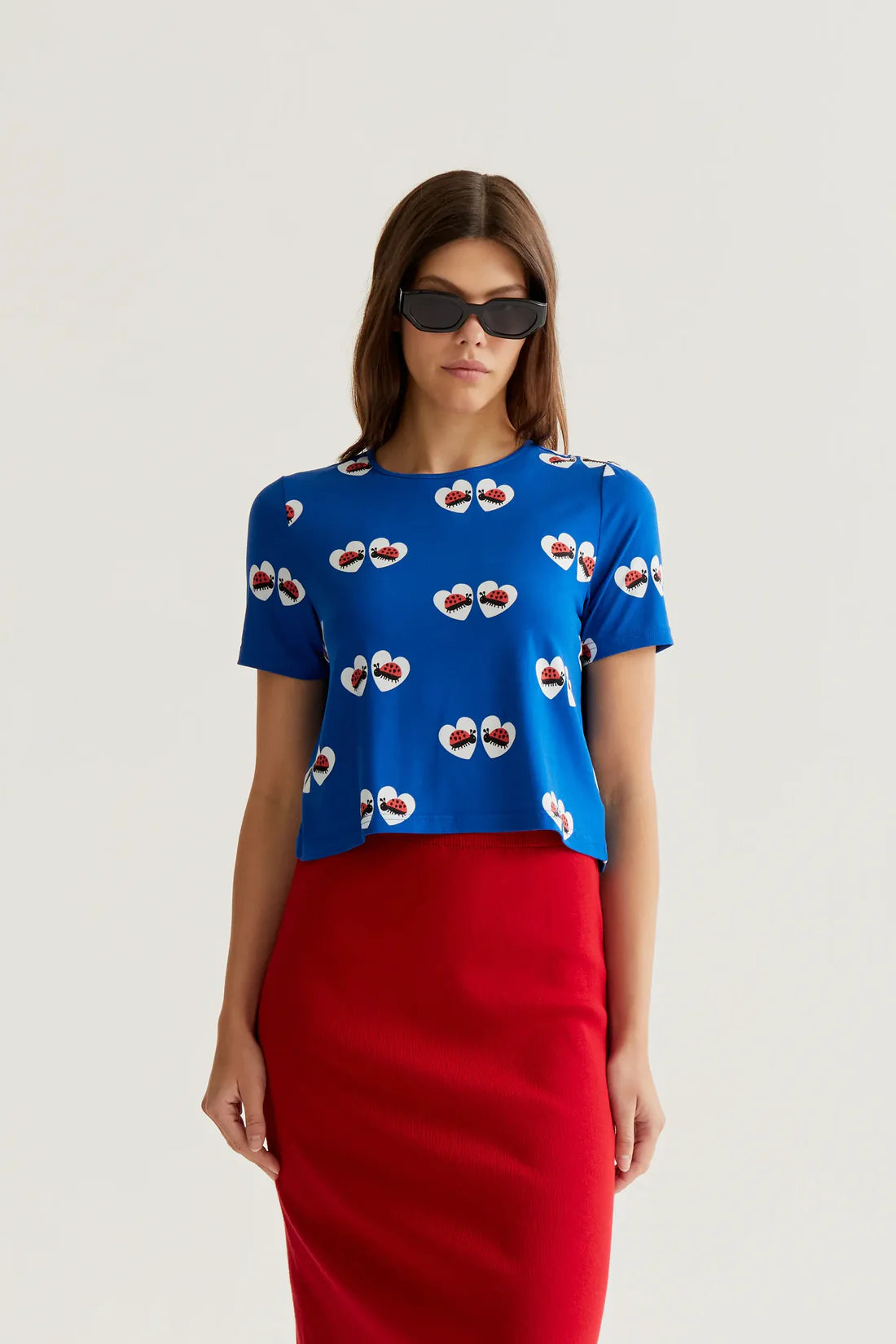 Women's royal blue ladybug heart print top with short sleeves, crew neckline and relaxed fit for playful summer style and boutique fashion.