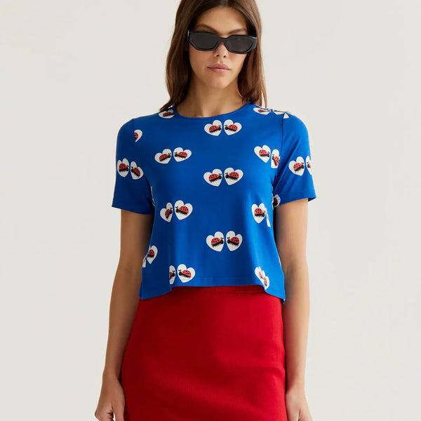 Women's royal blue ladybug heart print top with short sleeves, crew neckline and relaxed fit for playful summer style and boutique fashion.