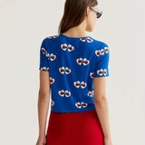 Bright cobalt blue short sleeve knit top featuring whimsical ladybug heart print and lightweight fabric for casual everyday wear.