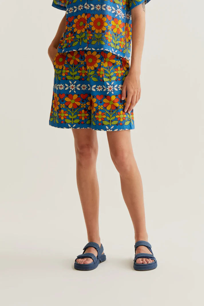 Women's blue retro floral print shorts with colorful botanical pattern, side pockets and relaxed fit for summer vacations and resort style.