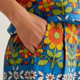Women's vibrant blue botanical print shorts with retro daisy pattern, relaxed silhouette and practical side pockets for everyday summer wear.