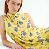 Modern coastal fashion dress showcasing playful fish illustrations, collared neckline, and button-front silhouette for resort wardrobes.