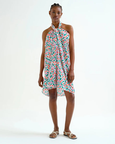 Young woman wearing a casual summer sarong with green, orange and pink cherry pattern.  Fun, sporty, beachy.