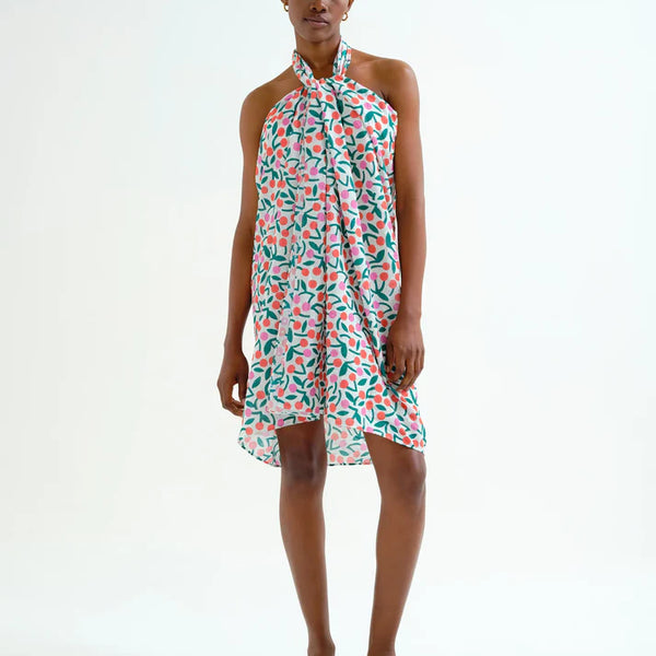 Young woman wearing a casual summer sarong with green, orange and pink cherry pattern.  Fun, sporty, beachy.