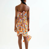 Back view, showing the back ties on a woman wearing a colorful floral sarong dress on a white background.  Sporty beachy.