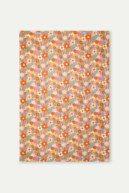 Floral patterned fabric of the sarong with colorful flowers on a white background.