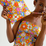 Colorful vintage-inspired floral zip pouch with quilted fabric, spacious interior, and bold yellow background for stylish travel essentials.