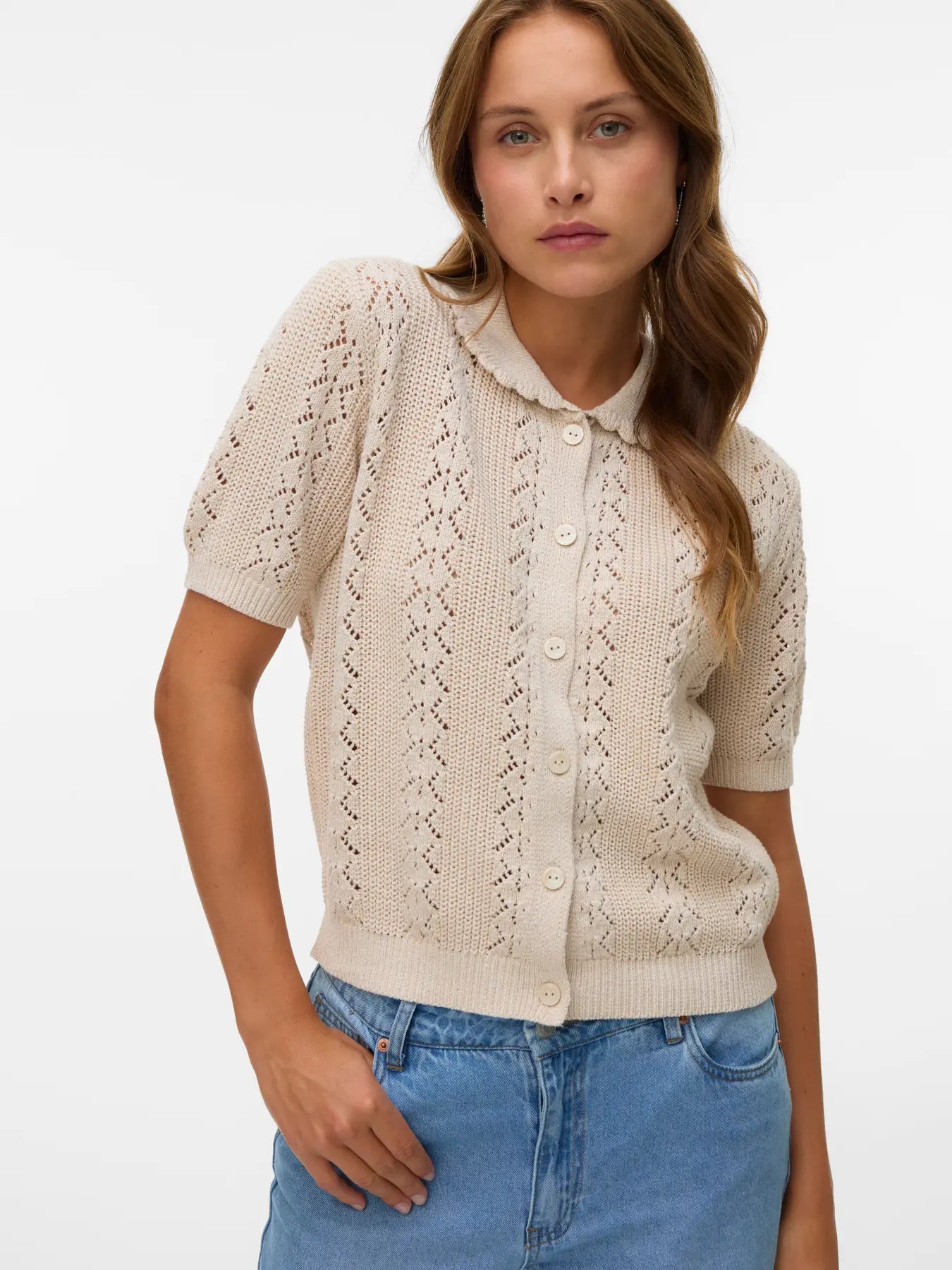 Soft neutral pointelle knit sweater cardigan with short sleeves, button-front closure and vintage-inspired silhouette for spring and summer layering.