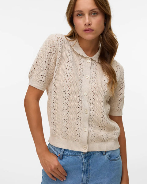Soft neutral pointelle knit sweater cardigan with short sleeves, button-front closure and vintage-inspired silhouette for spring and summer layering.