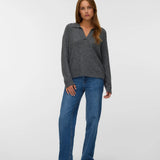 Charcoal grey knit pullover for women with a polo collar, V-neckline and relaxed silhouette styled with blue jeans.