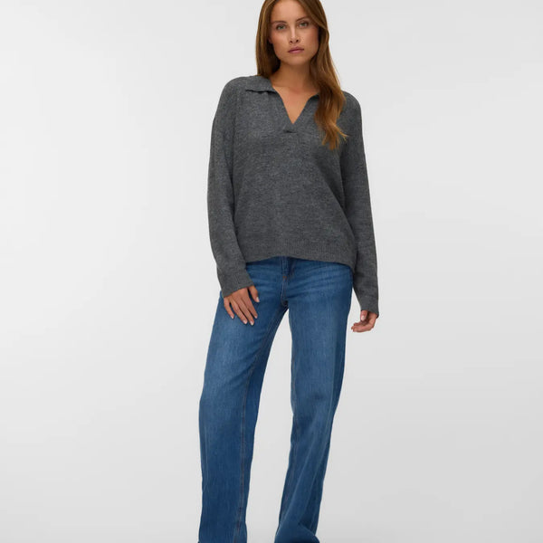Charcoal grey knit pullover for women with a polo collar, V-neckline and relaxed silhouette styled with blue jeans.