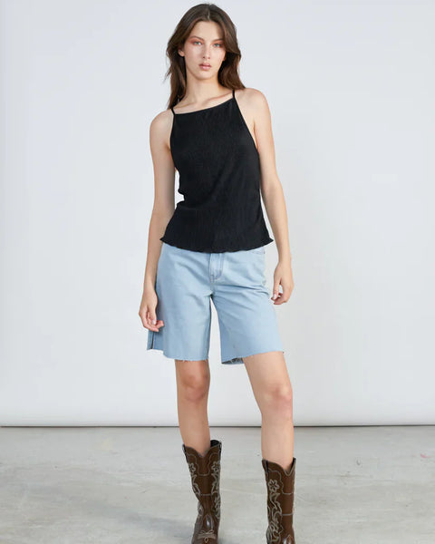 Fashion-forward denim Bermuda shorts with raw hem and elevated street style summer aesthetic.