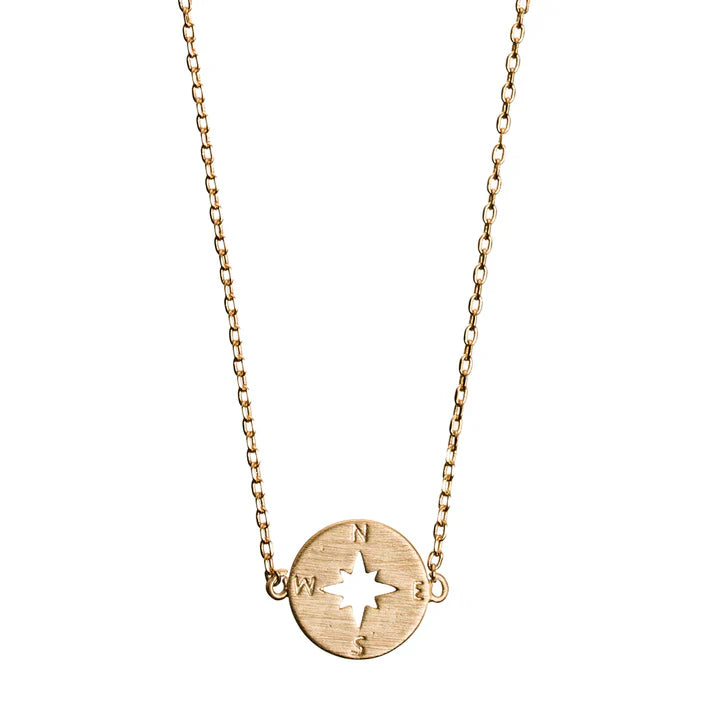 Gold layering necklace featuring a compass disc pendant and minimalist jewelry design.