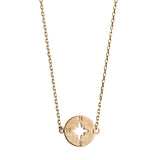 Gold layering necklace featuring a compass disc pendant and minimalist jewelry design.