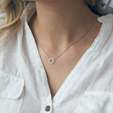 Minimalist gold dreamcatcher pendant necklace styled with a white linen blouse for effortless elegance.
