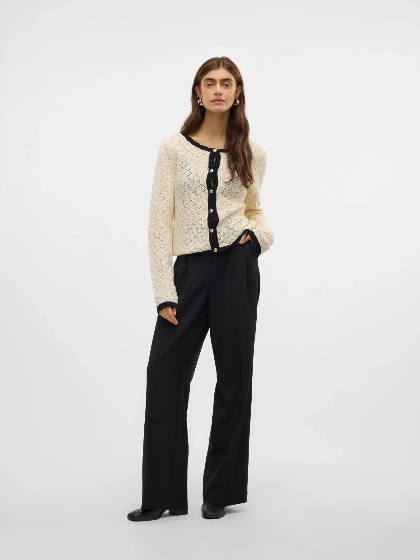 Cream open-knit button-front cardigan featuring black trim, long sleeves and lightweight pointelle texture for timeless boutique fashion.