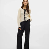 Cream open-knit button-front cardigan featuring black trim, long sleeves and lightweight pointelle texture for timeless boutique fashion.