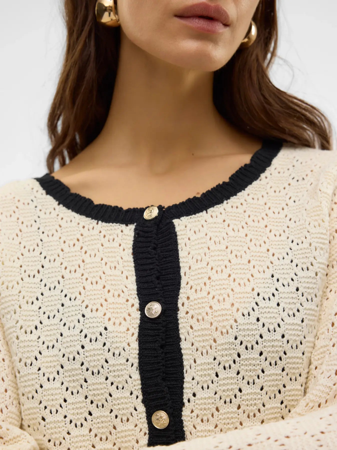 Women's Parisian-inspired pointelle cardigan with long sleeves, round neckline and elegant black trim for business casual and weekend outfits.