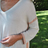 Women’s cozy oversized sweater in cream with subtle pink trim and flowy fit for effortless contemporary fashion.