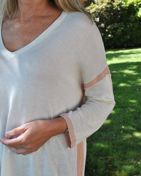 Women’s cozy oversized sweater in cream with subtle pink trim and flowy fit for effortless contemporary fashion.
