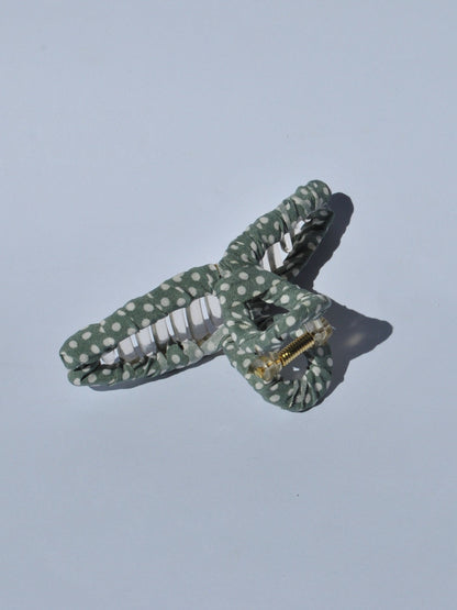 Fashion-forward women’s claw clip featuring soft green fabric and white dot print for easy messy bun hairstyles.