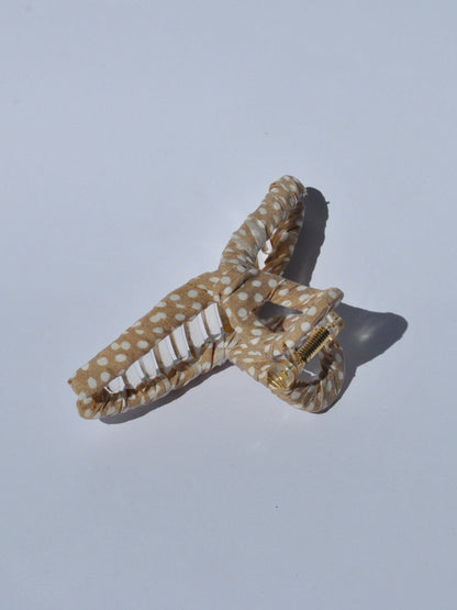 Women’s trendy claw hair clip in gold and white polka dot print with oversized shape for quick effortless hairstyles.