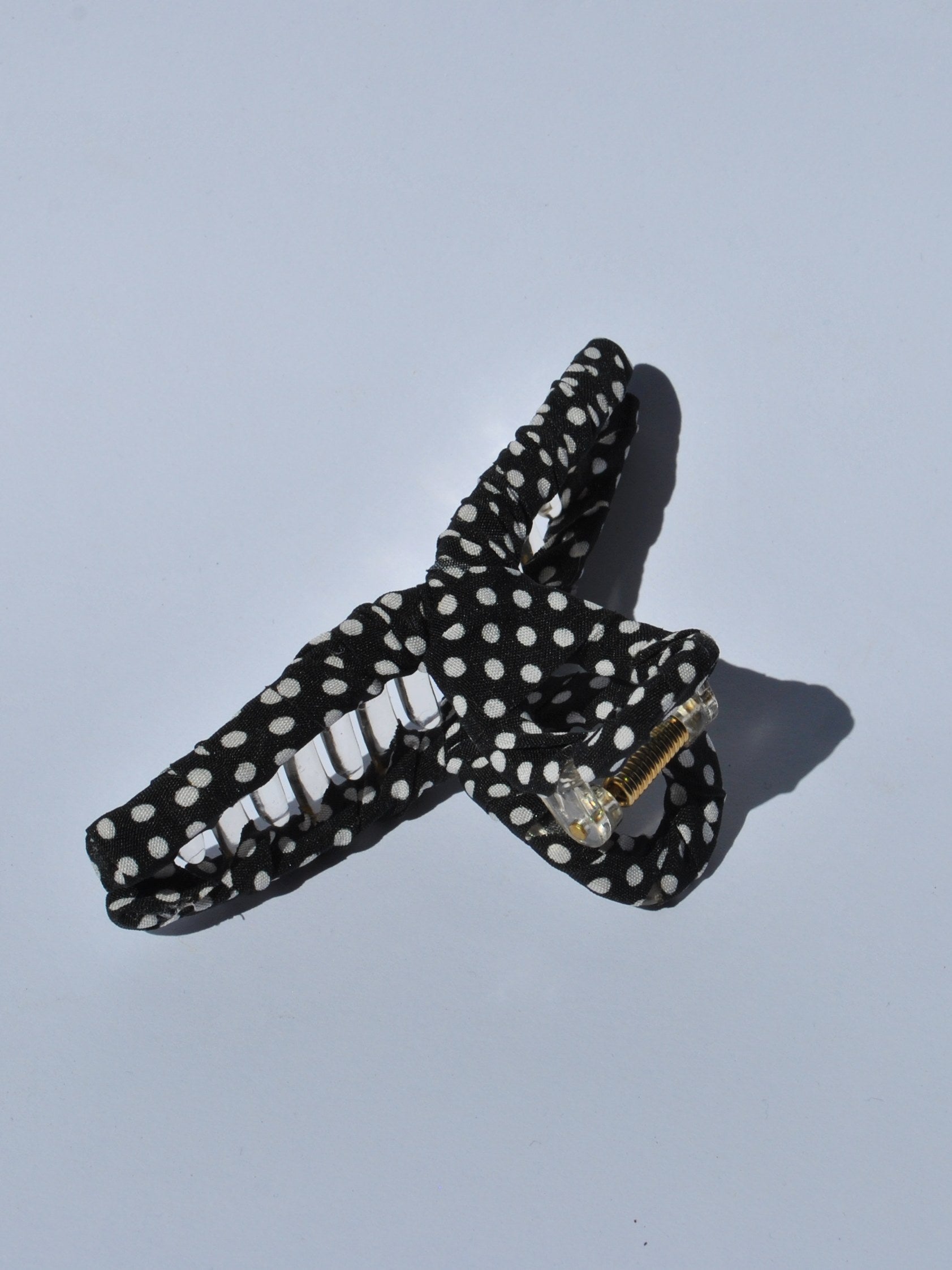 Cute retro-style black polka dot hair claw with lightweight construction and strong grip for casual fashion looks.