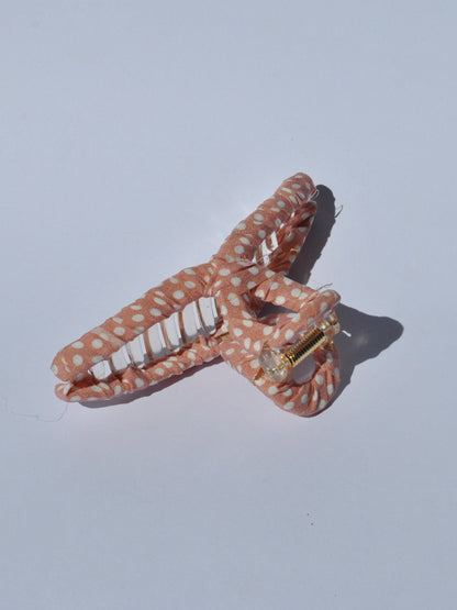 Trendy coral polka dot claw clip for women with durable grip and soft fabric texture for stylish hair updos.